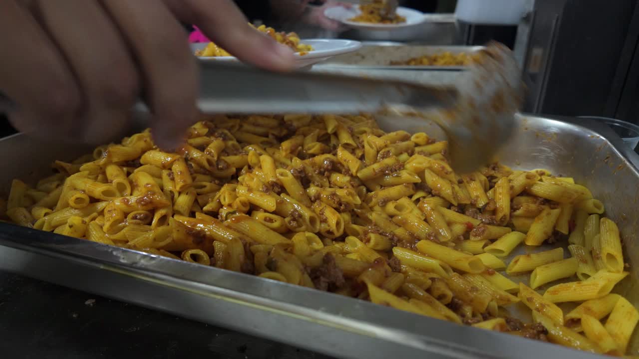 A large-scale catering service, featuring a hearty pasta dish served with fried plantains