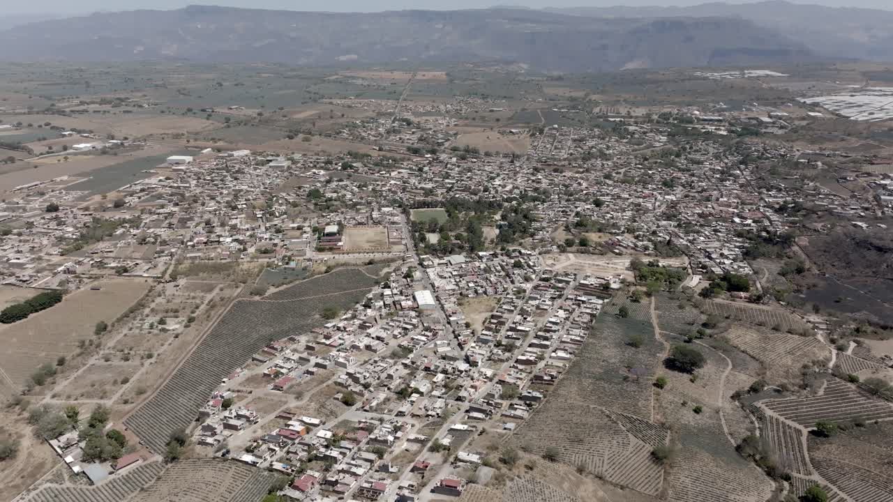 Drone shot of Amatitan surrounded by blue agave agricultural lands, Jalisco