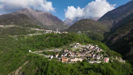 Drone-crane-motion-toward-picturesque-Alp-village-in-lush-hillside-forest