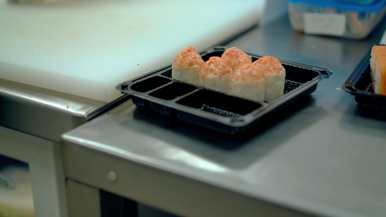 el chef sirve un rollo japonés con salsa.