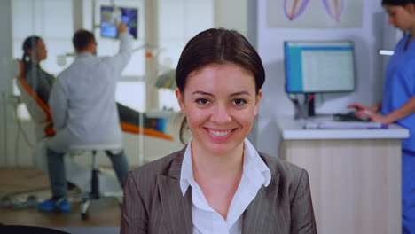 portrait of smiling young patient looking on webcam sitting on chair