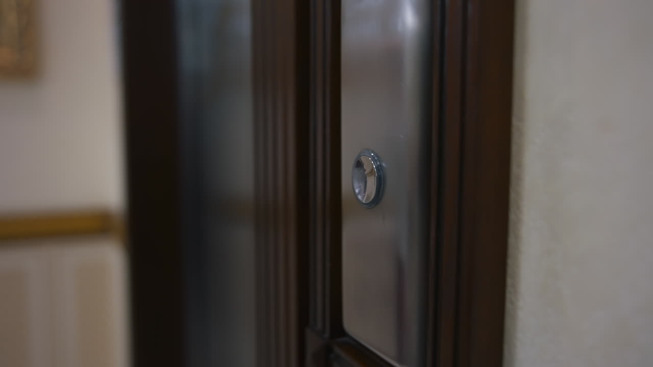 Woman`s hand presses button in an elevator. Unrecognizible woman in white shirt enters elevator. Selective focus.