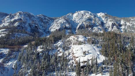 Schwenk-Nach-Links,-Drohnenaufnahme-Von-Schneebedeckten-Bergen-In-Der-Wildnis