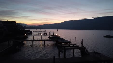 drone shot of kelowna city beach docks on okanogan lake with sunset