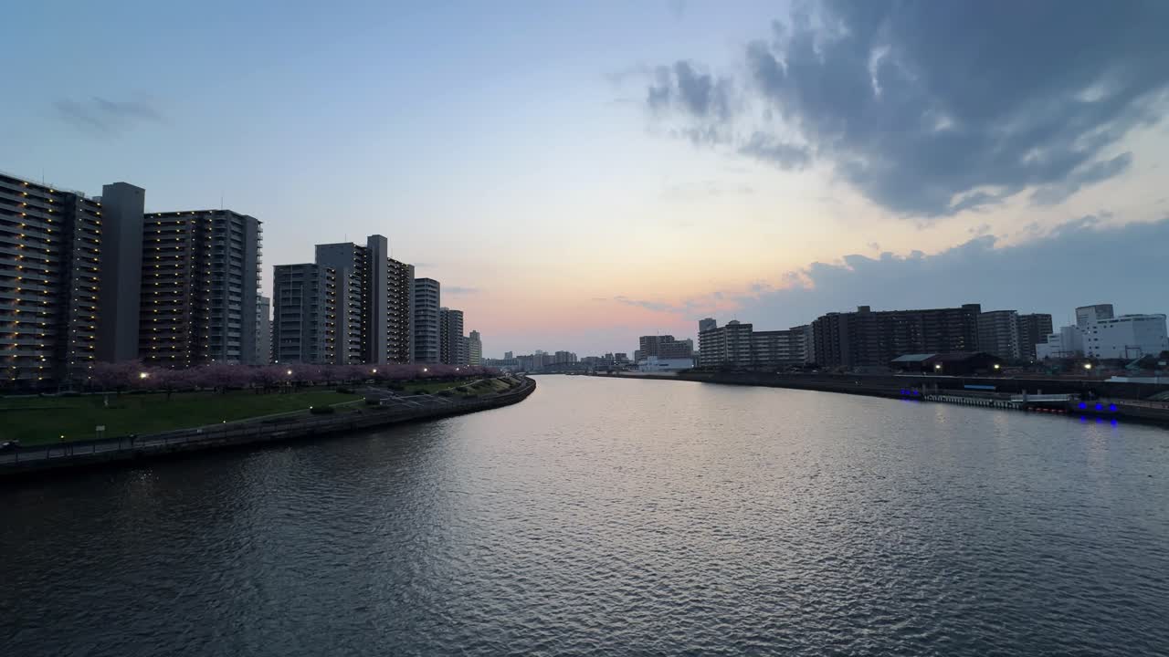 Scenic view of the river in Tokyo, Japan with apartment buildings and sunset sky