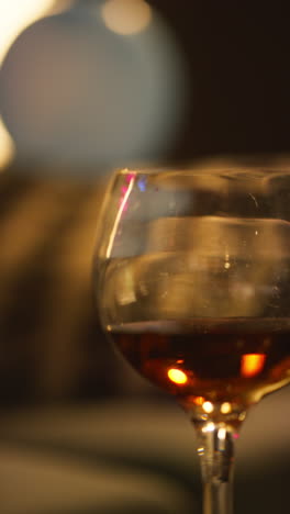 vertikale nahaufnahme von rotwein im glas auf dem tisch nach der hausfeier