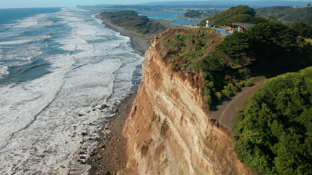 paisaje aéreo que muestra la costa de puerto saavedra, chile con escarpados acantilados rocosos en un día soleado