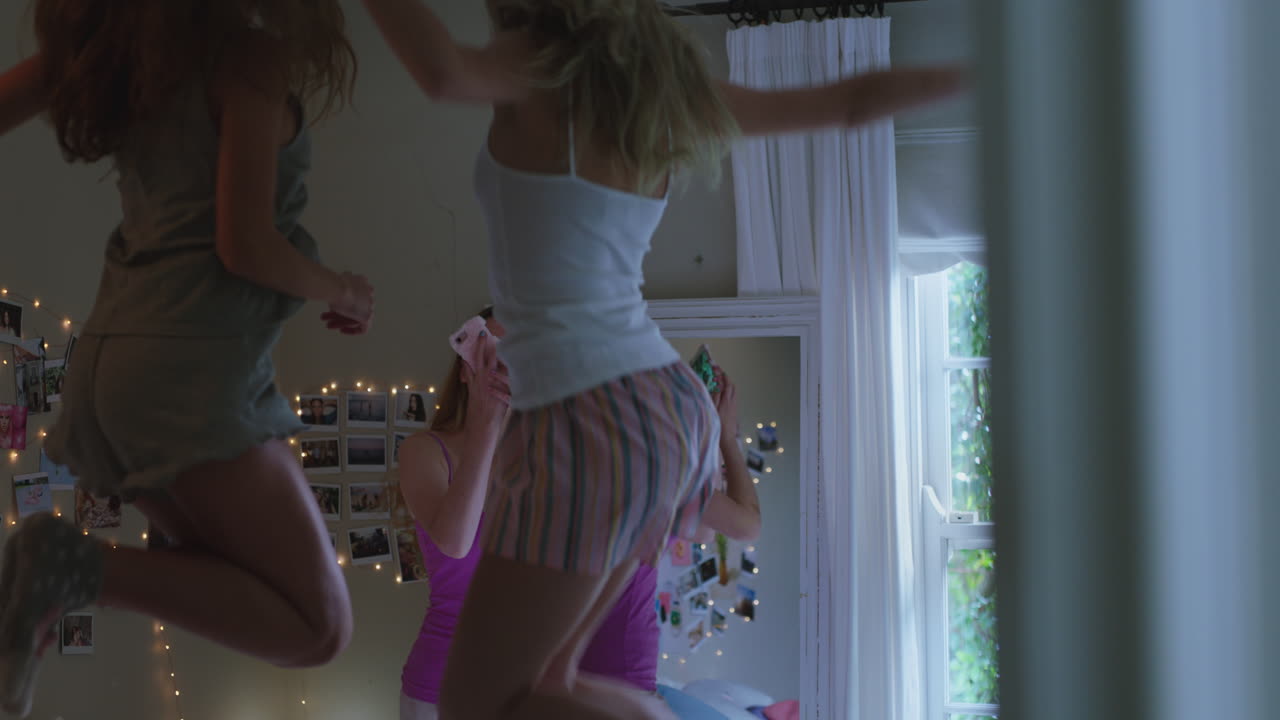 glückliche teenager, die zu hause auf das bett springen, beste freunde, die zusammen feiern, freund, der smartphones nutzt, teilen, genießen, teilen, feiertage in sozialen medien feiern