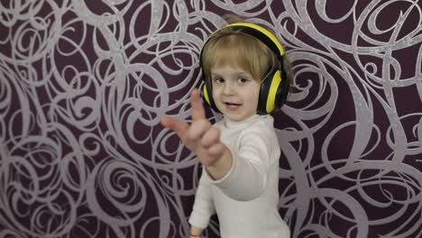 Un-Niño-Feliz-Bailando-En-El-Sofá-Y-Escuchando-Música-Con-Auriculares-En-Casa