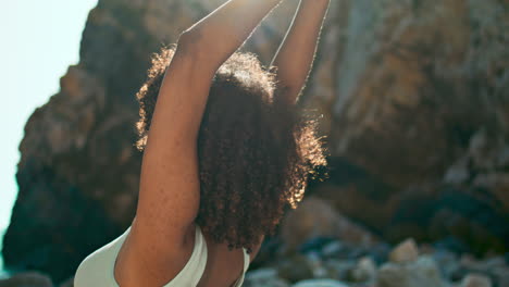 Girl-standing-warrior-pose-under-sunlight-outdoors-close-up.-Woman-training-yoga