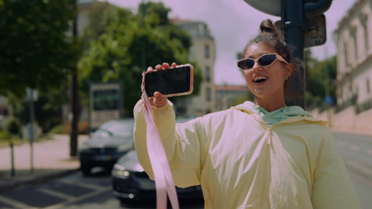 Ung kvinne vlogger og snakker i smarttelefon på bygata