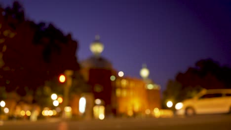 Alter-Stadtplatz-Bei-Nacht-Mit-Vorbeifahrenden-Autos-Und-Fußgängern