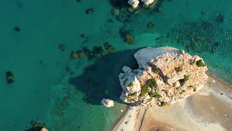 top down zoom out aphrodite rock cyprus emerald green and blue ocean