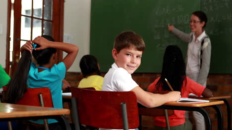 Un-Niño-Pequeño-Se-Vuelve-Para-Sonreír-A-La-Cámara-Durante-La-Clase