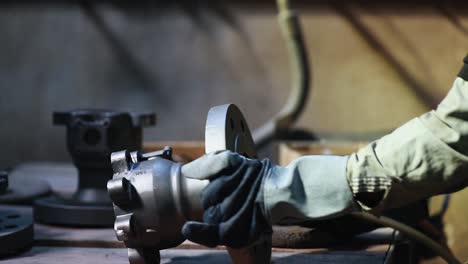 industrial safety first concept, worker producing sparks from cutting a loop of steel pipe with a circular grinder