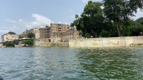 navegando a lo largo del lago pichola revelando el palacio de la ciudad de udaipur