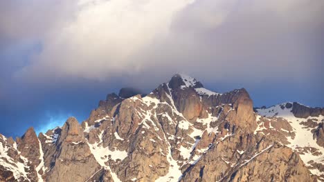 Rocky-snowy-mountains-under-cloudy-sky