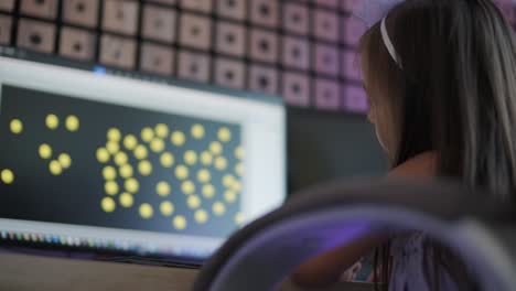 a little girl in a beautiful dress is drawing on a personal computer