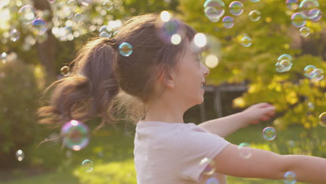 Spinnendes-Mädchen-Im-Freien,-Das-Spaß-Beim-Spielen-Mit-Blasen-Im-Garten-Hat