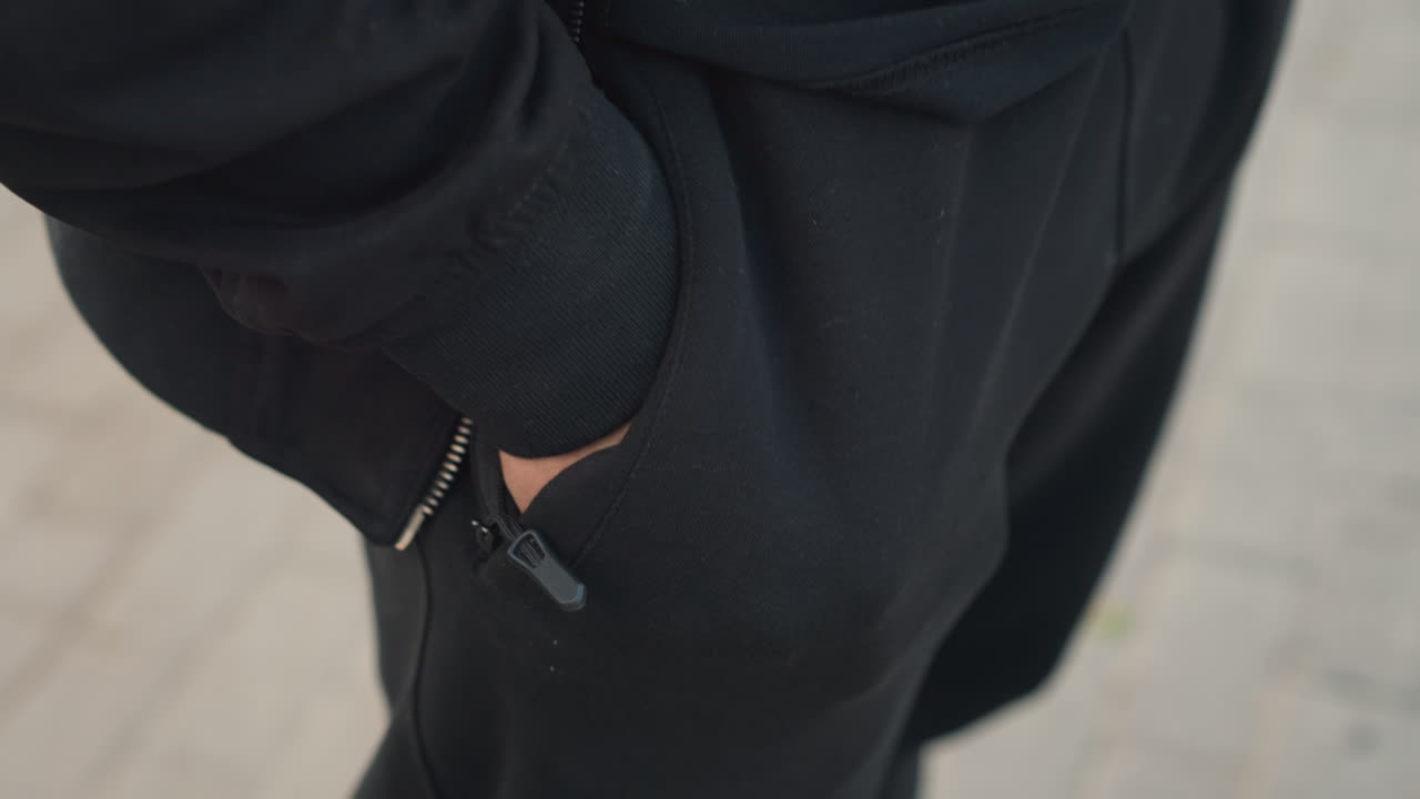 paseo urbano informal; hombre caminando cómodamente al aire libre; escena cotidiana de un hombre con ropa informal en la acera de la ciudad; primer plano de un hombre relajado con ropa informal caminando por una zona urbana pavimentada