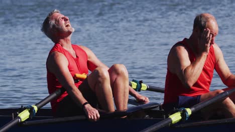 two senior caucasian men in rowing boat resting