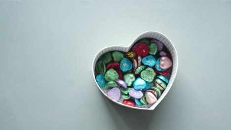 Kleines-Herzförmiges-Geschenk-Mit-Süßigkeiten-Auf-Grauem-Hintergrund