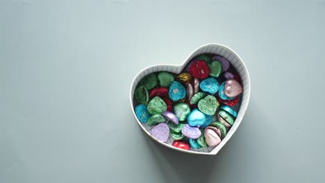 Pequeño-Regalo-En-Forma-De-Corazón-Con-Dulces-Sobre-Fondo-Gris-R