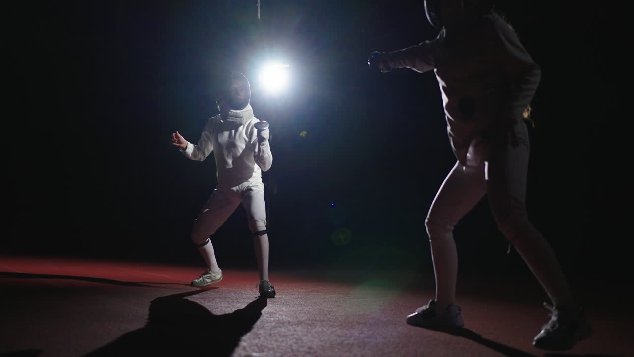 Two fencers compete in a match