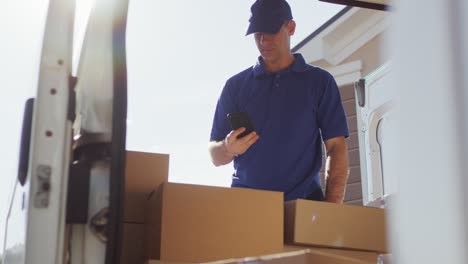 delivery man at van scanning boxes with barcode scanner