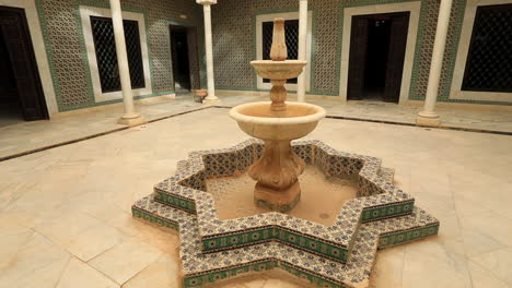 patio de una casa árabe con fuente ornamentada en sbeitla, iluminado por el sol y tranquilo