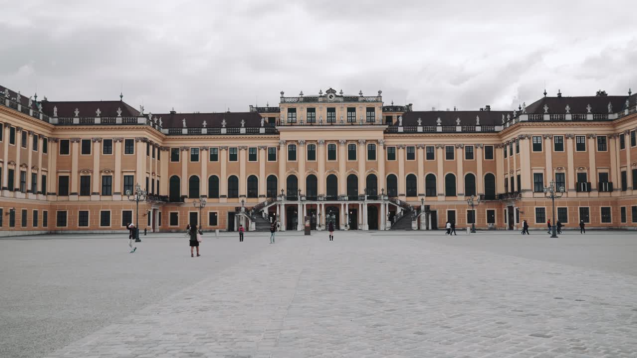 Walking towards the Castle Schönbrunn in Vienna Austria while people exploring the place on a cloudy day
