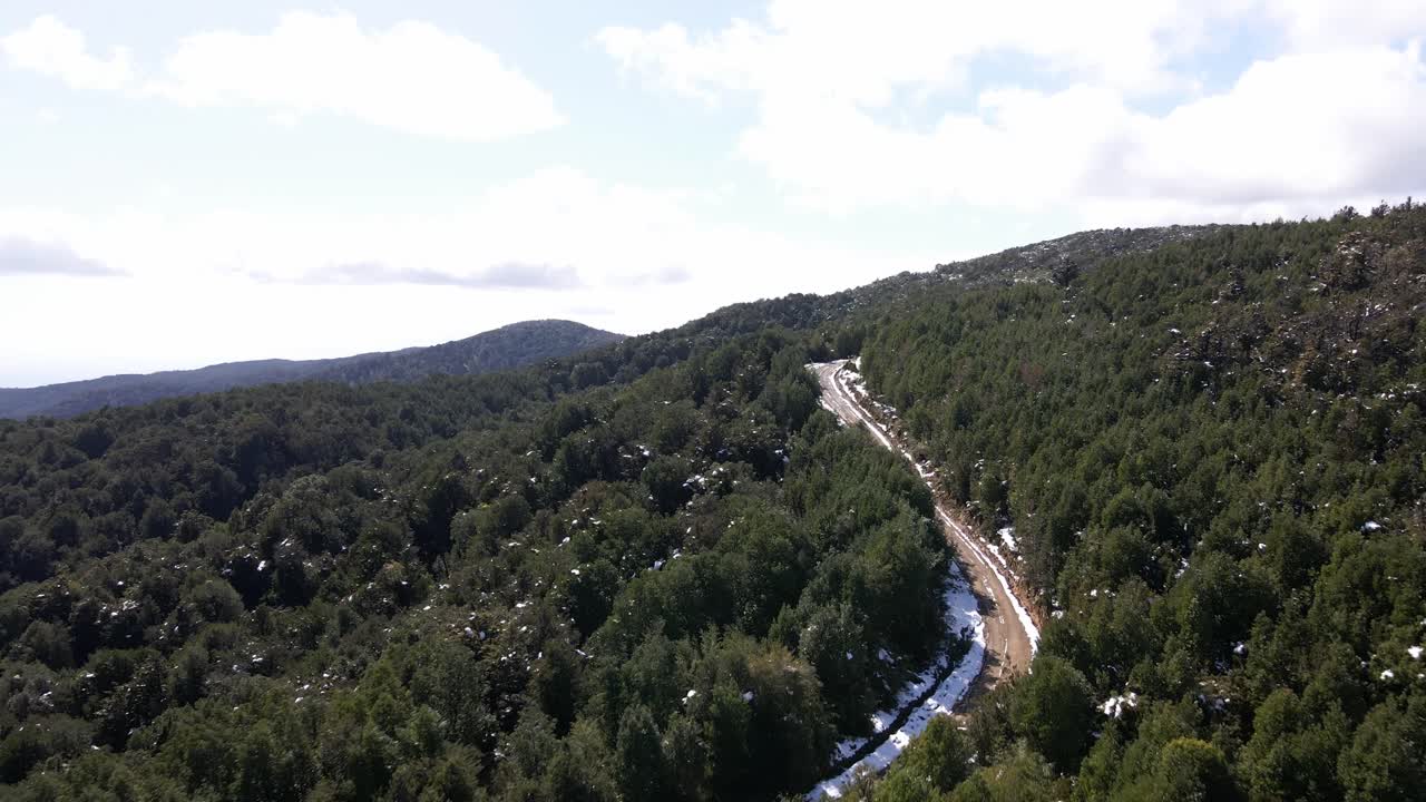 vista aérea de un camino de tierra en el bosque nevado en el parque oncol, chile