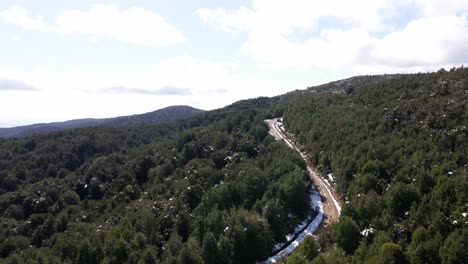 Aerial-push-out-view-of-a-dirtroad-in-the-snowy-forest-in-Oncol-Park,-Chile