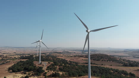 drone takes off rising over wind turbines in rural area on sunny day