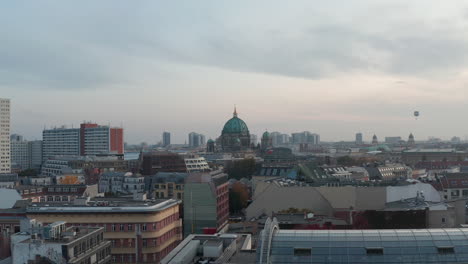 Low-flight-above-building-roofs-near-city-centre.-Heading-towards-monumental-church-of-Berlin-cathedral-with-large-dome.-Berlin,-Germany.