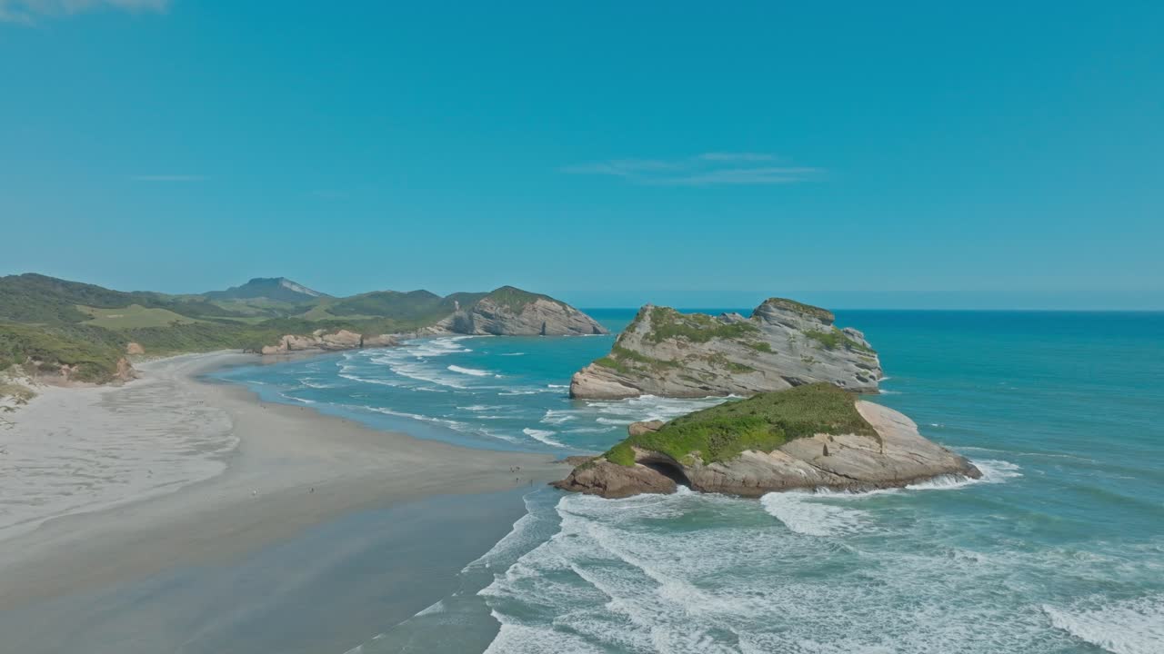 Vista panoramica aerea con drone di affioramenti rocciosi unici presso la popolare destinazione turistica di Wharariki Beach in una giornata di sole a Cape Farewell, Nelson, Isola del Sud della Nuova Zelanda Aotearoa