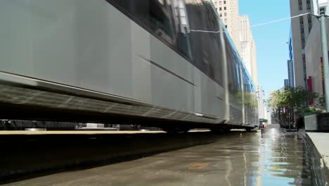 a rapid transit train moves quickly through downtown houston with fountains dancing 2