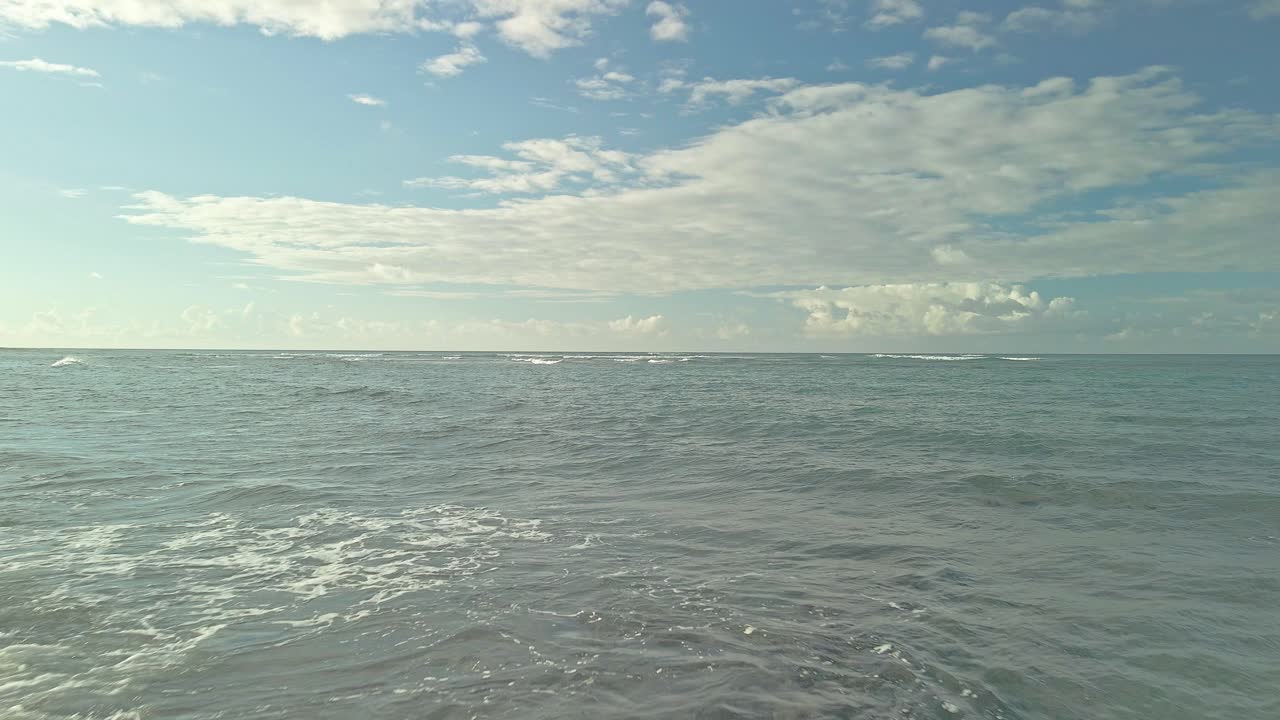 vista aérea de barrido bajo de la playa rocosa rozando las aguas del océano