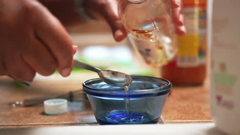 measuring apple cider vinegar into a small glass bowl to add to a homemade recipe - slow motion