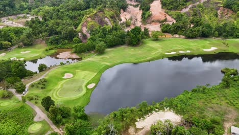 aerial view of a lush golf course in phuket, thailand, showcasing vibrant greens and serene water features under natural lighting