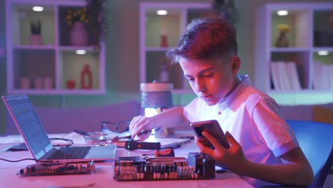 the boy who is interested in technology examines the card with the computer.