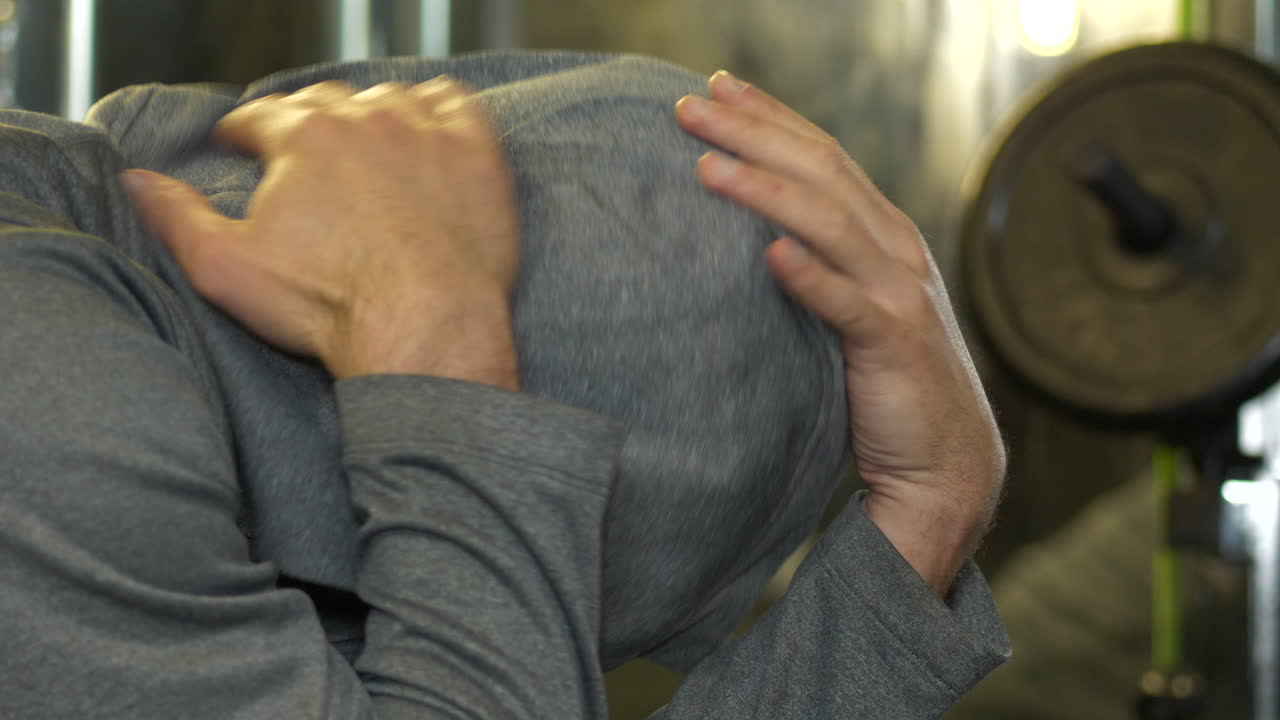 체육관에서 후드 티를 입은 슬픈 우울한 남자, 돌리는 r에서 l로 총을 맞았습니다.