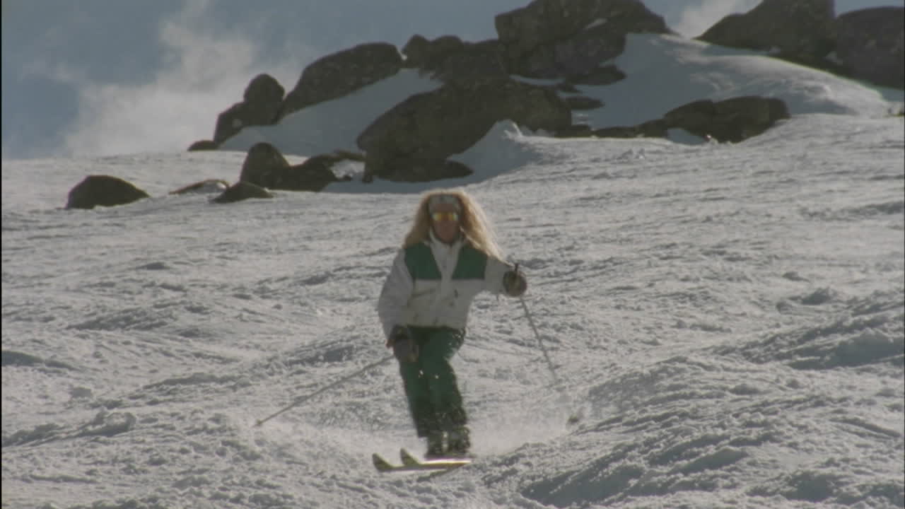 человек, спускающийся на лыжах по склону