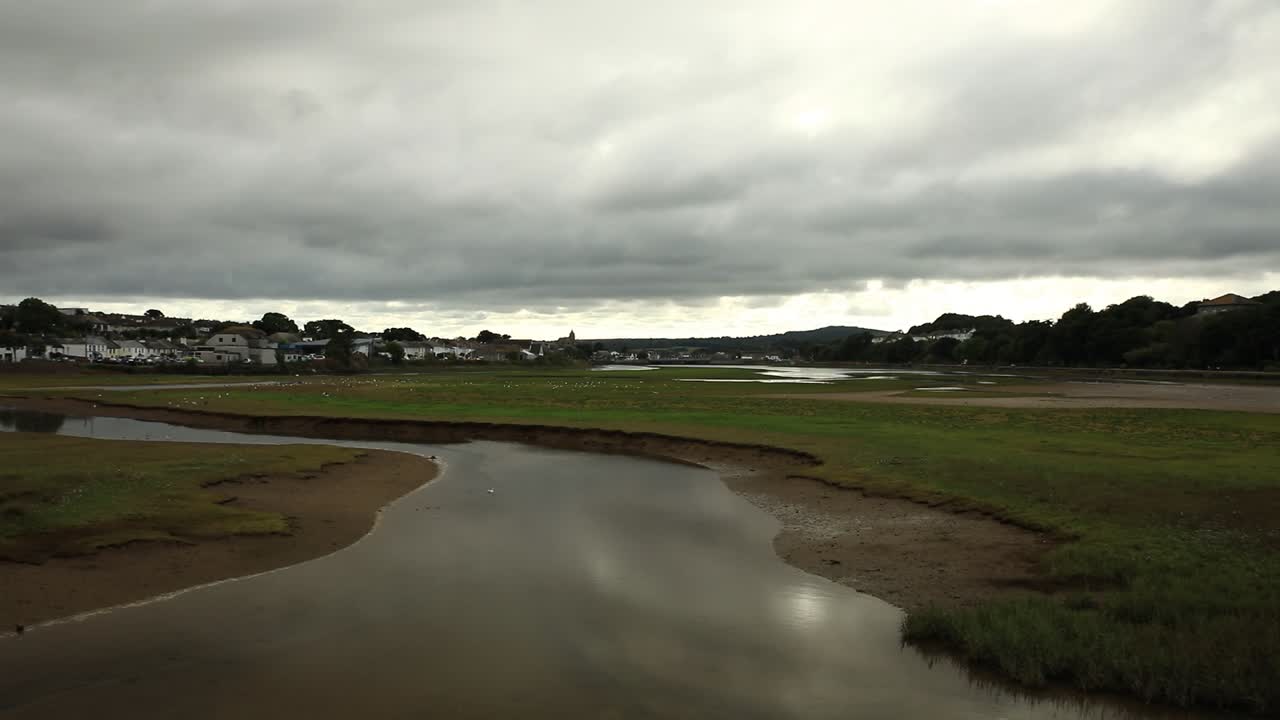 Ripresa con zoom all'indietro del lago limpido nella riserva naturale di Hayle, riflesso del cielo, Cornovaglia, Inghilterra.