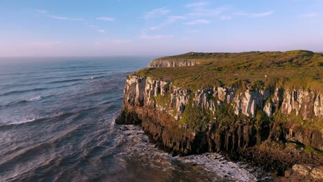 aerial cinematic shot of high rocky cliffs moving backwards