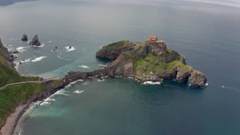 Océano-Ondulado-Cerca-De-La-Montaña-Verde-Con-Pasarela-Bajo-El-Cielo