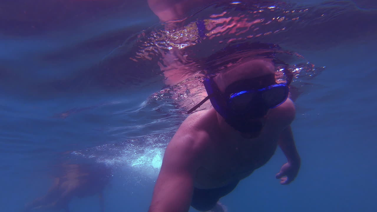 슬로우 모션 | 바다에서 물고기를 찾는 남자 스노클링