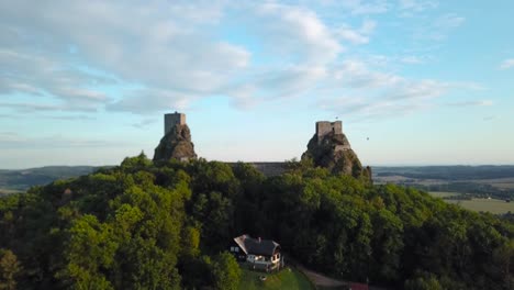 Trosky-castle-at-Bohemian-Paradise-during-a-golden-hour-with-balloons-in-the-distance,-fly-through,-4k-or-UHD,-30fps