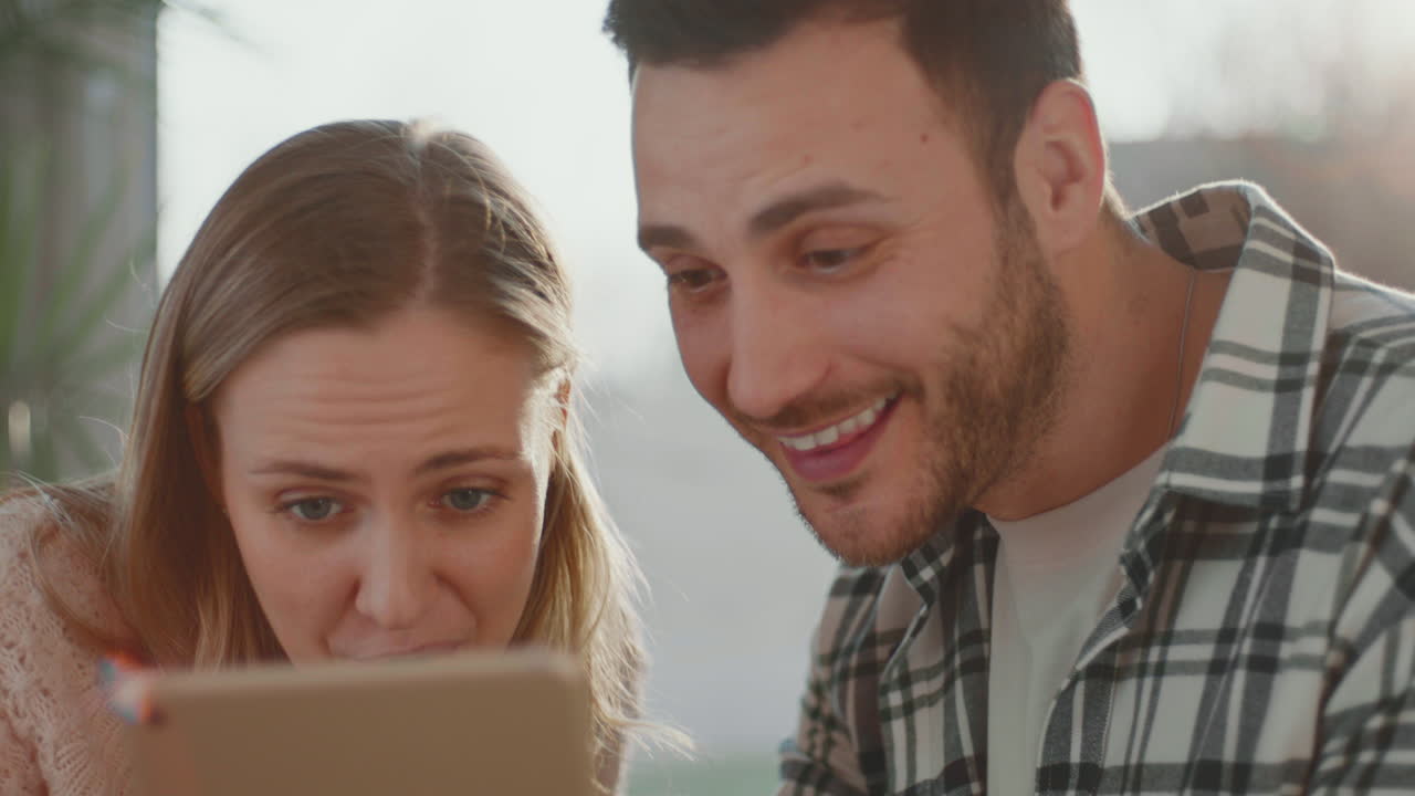 una pareja joven usando una tableta.