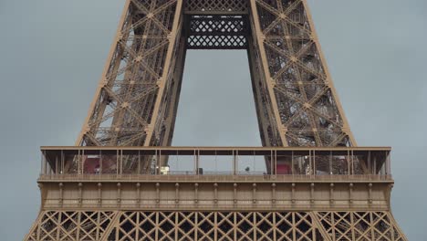 first floor of eiffel tower with cloudy sky in background